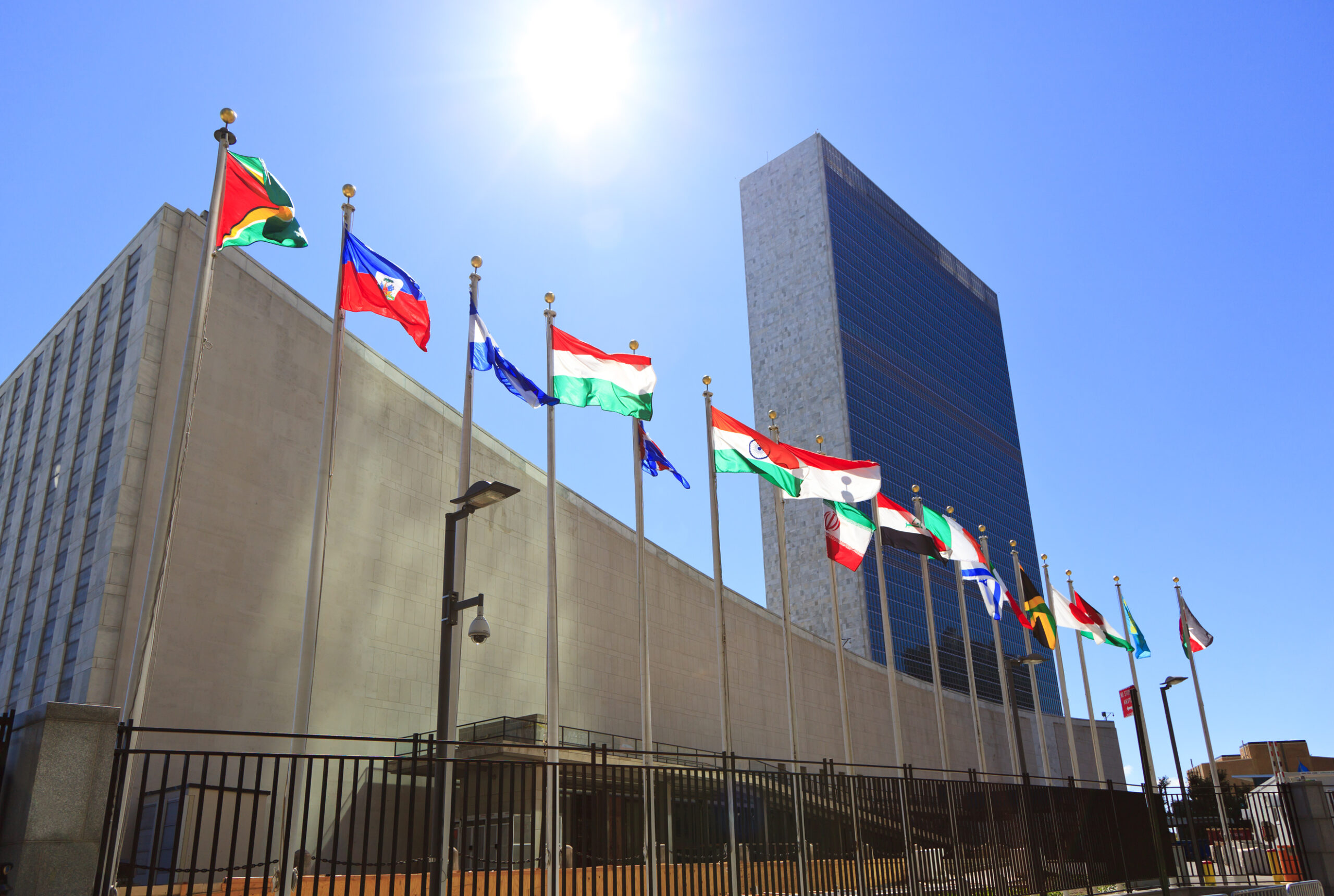 United Nations Headquarters with waving flags in New York, USA